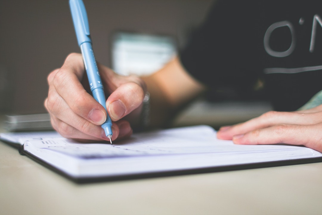 Una mano escribiendo en una lista - Foto de picjumbo.com en Pexels