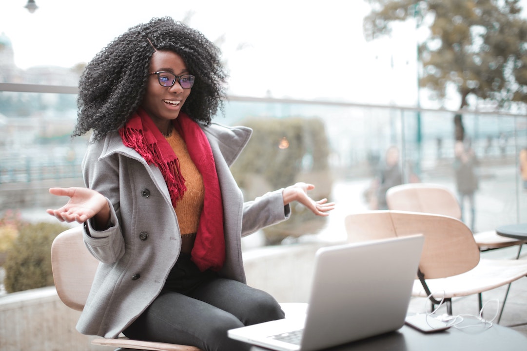 Una mujer alegre frente a su ordenador - Foto de Andrea Piacquadio Pexels