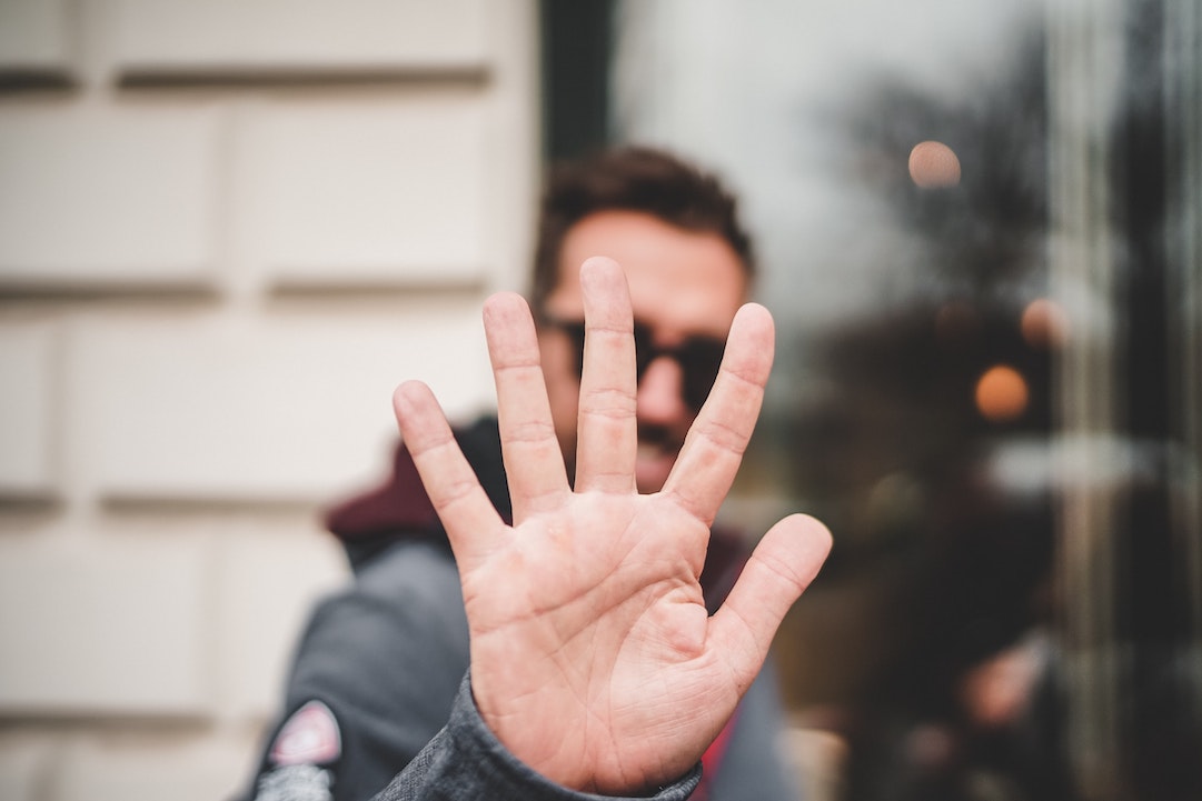5 razones por las que no obtienes respuesta de tu lista de correo electrónico - hombre mostrando su mano con 5 dedos