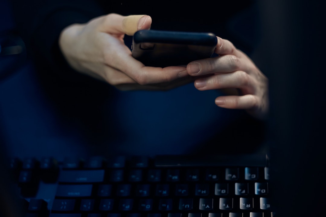 Modo oscuro - Foto de una persona con un teléfono y un teclado negros