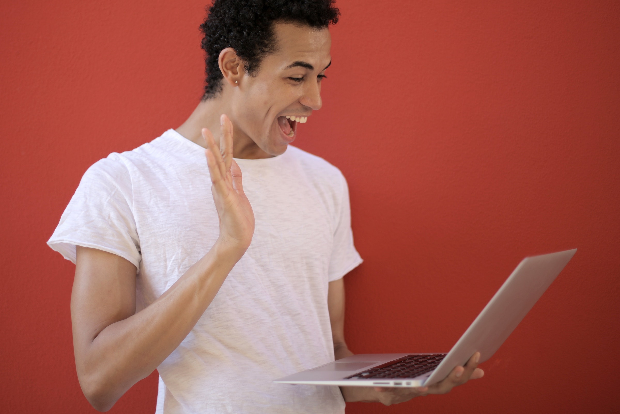 Hombre sonriendo ante un ordenador feliz de ver su correo electrónico personalizado - Foto de Andrea Piacquadio - Pixels