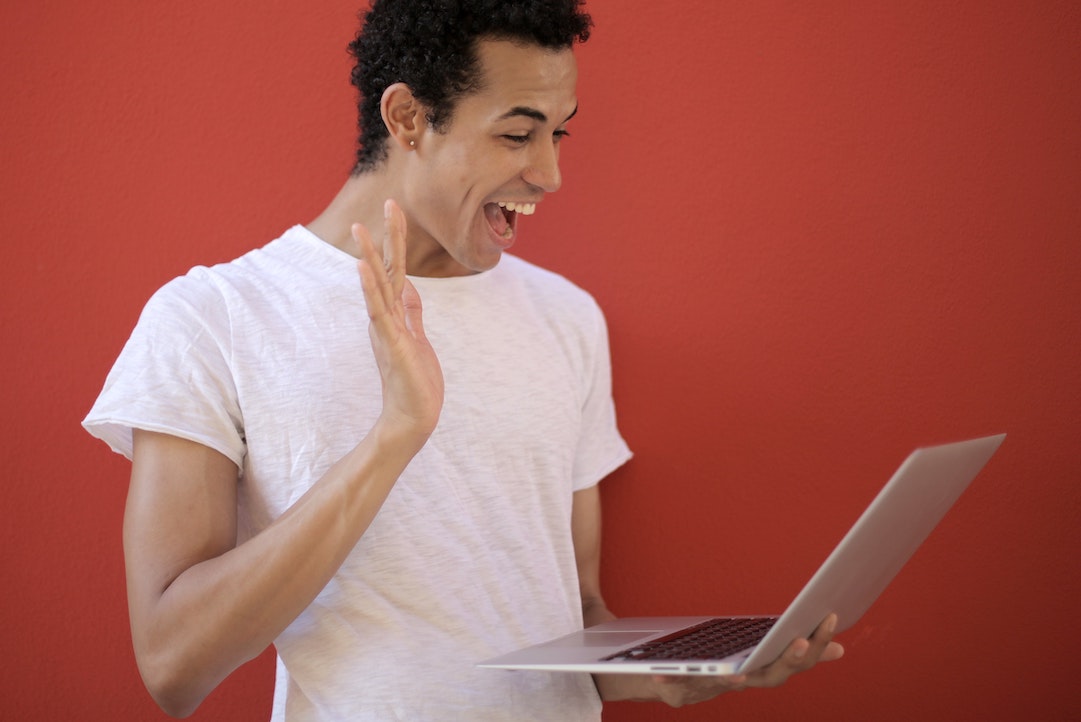 Hombre sonriendo ante un ordenador feliz de ver su correo electrónico personalizado - Foto de Andrea Piacquadio - Pixels