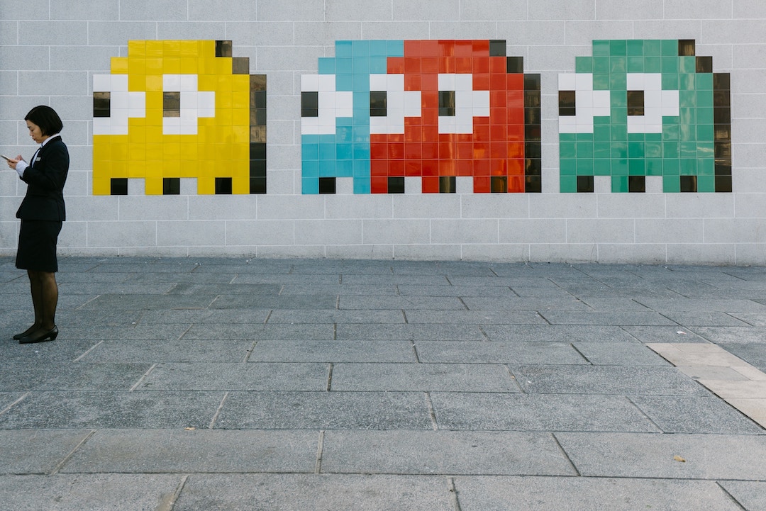 Pacman observando a una dama en una pared - Foto bady abbas - Unsplash