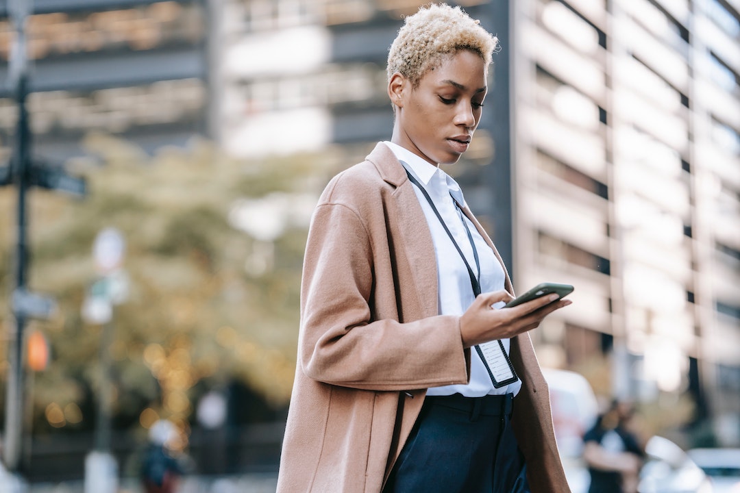 Foto de una mujer en una ciudad mirando su móvil - Foto de Ono Kosuki - Pexels
