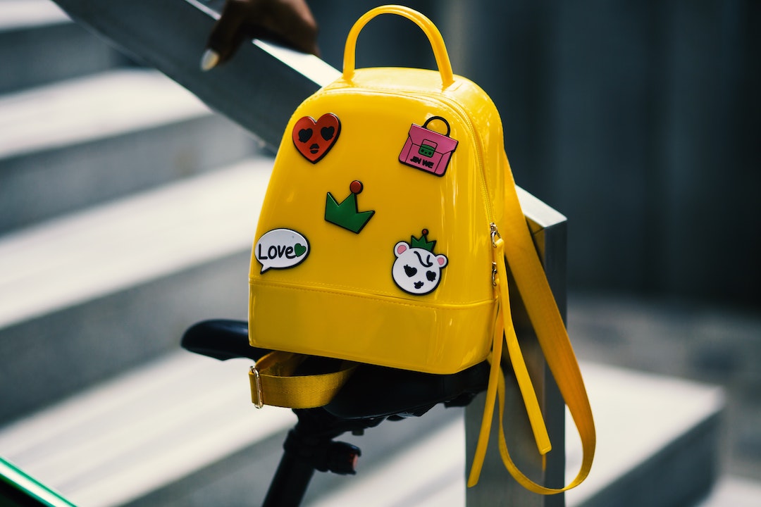 Mochila escolar amarilla colgada en una rampa con escaleras