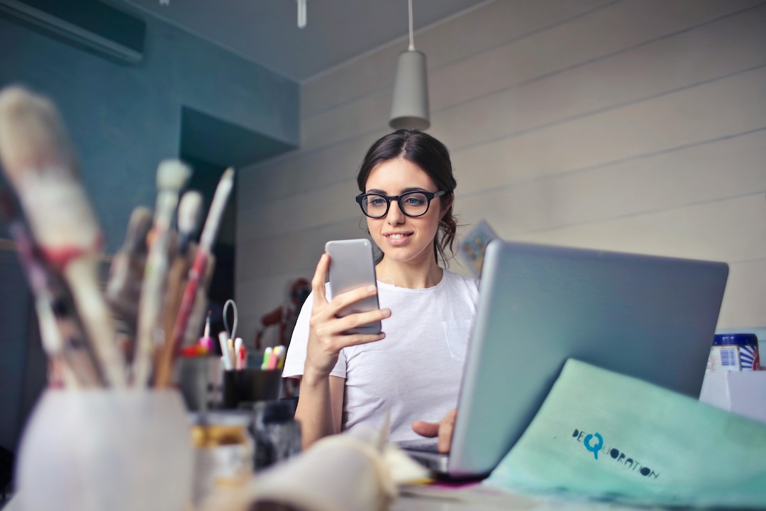 Mujer trabajando y mirando el teléfono. - Foto Andrea Piacquadio - Pexels